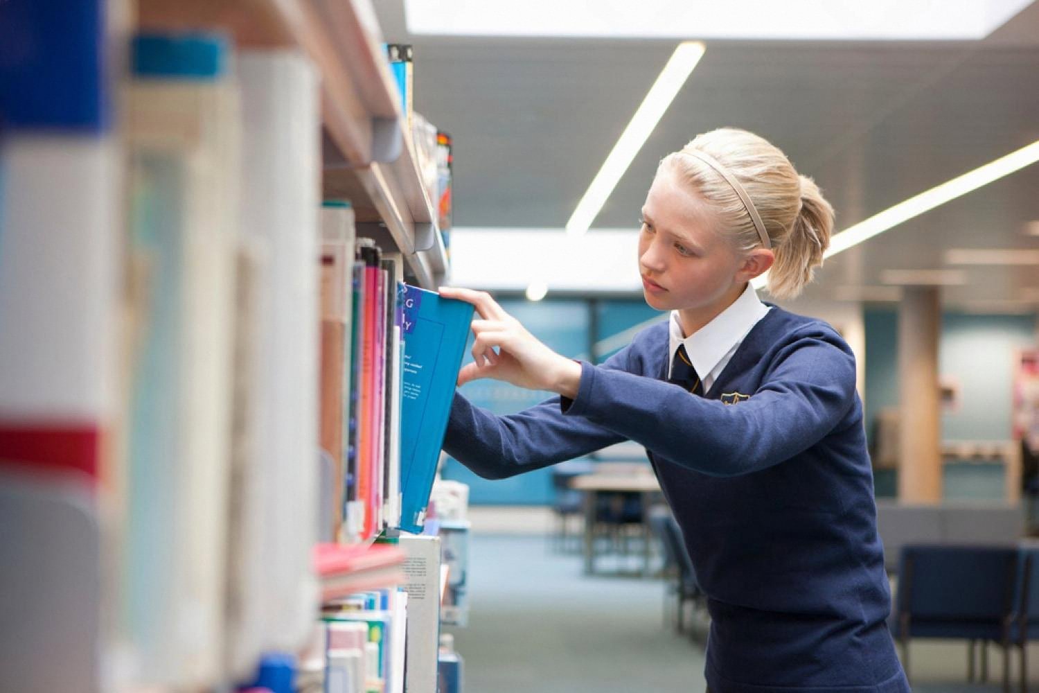 Student picking a book in a well-stocked school library in the UAE