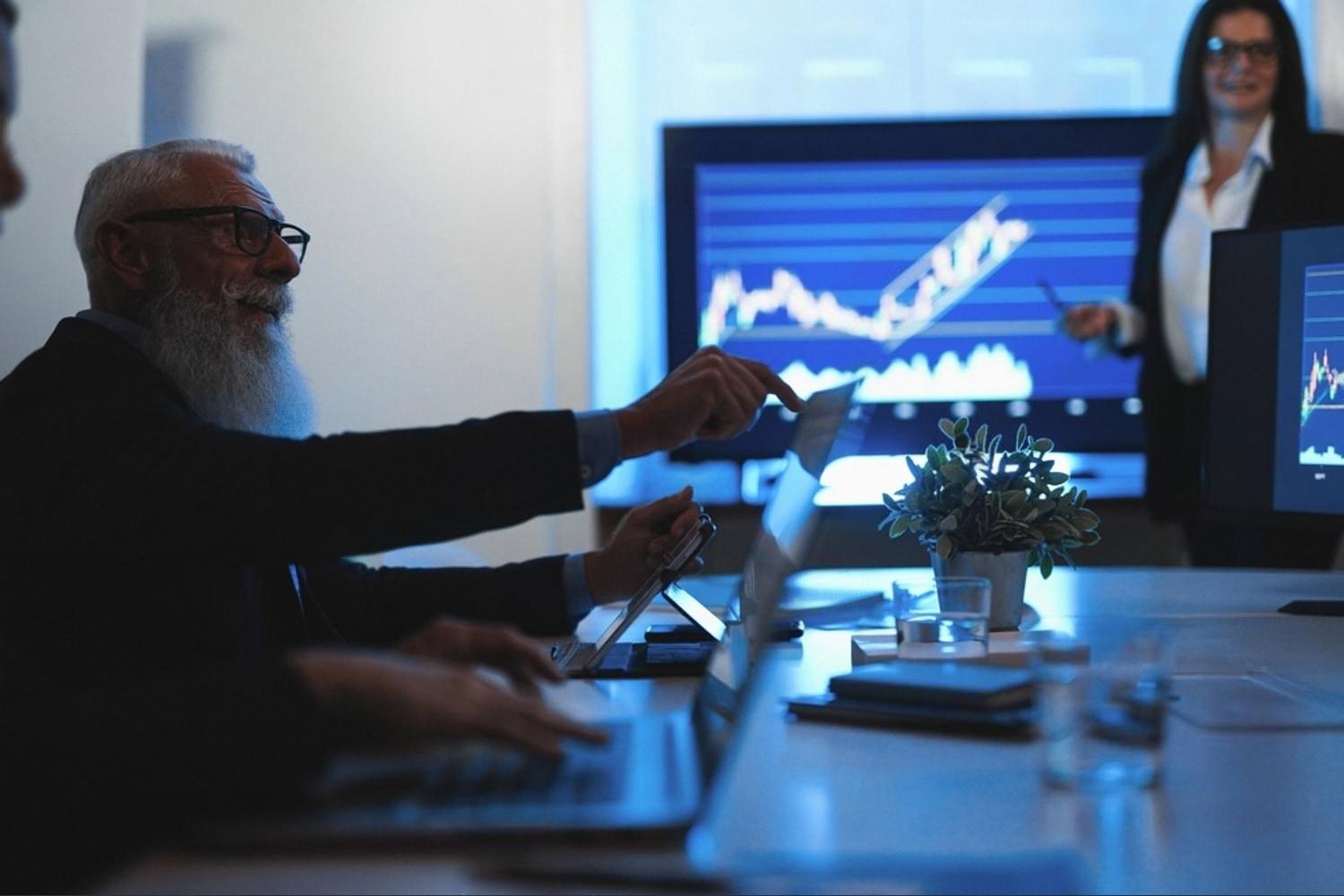 Senior executive analysing corporate risk charts on screens during a UAE board meeting
